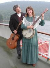 photo of Dave Para holding a guitar, and Cathy Barton holding a banjo