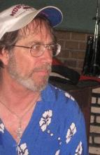 photo of Derek Lamson wearing a Hawaiian shirt and white baseball cap