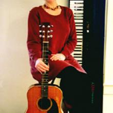 Photo of Carol with her guitar.