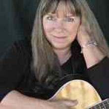 photo of Priscilla Herdman holding her acoustic guitar